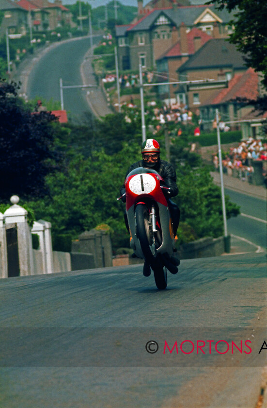 001 - Agostini 
 Ago's leap
The most iconic shot in the Nick Nicholls Collection. Taken at the 1970 Isle of Man TT, Giacomo Agostini on a 500cc MV-5.