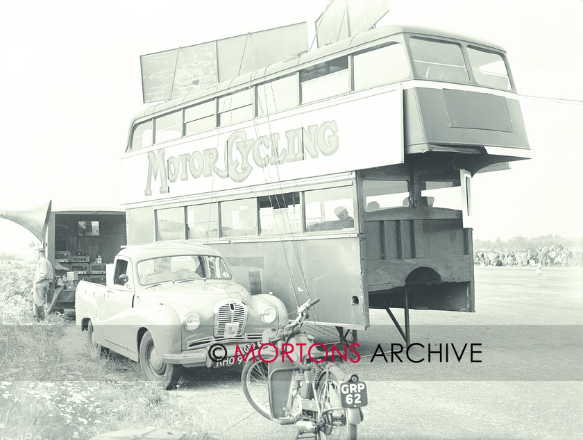 062 SFTP 05 
 1954 Ibsley Airfield racing - The fantastic commentary box - a chassis-less bus body. The pick-up is a rather bent Austin A40, while the motorcycle is a James two-stroke. 
 Keywords: 2012, Mortons Archive, Straight from the plate, The Classic MotorCycle