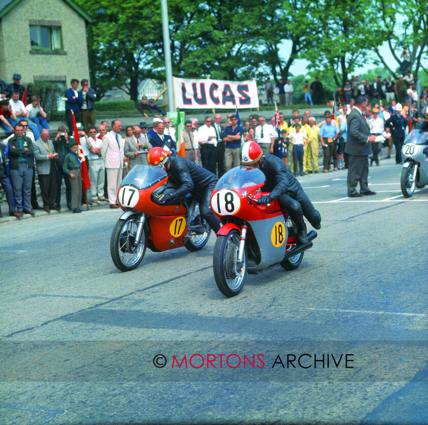 Agostini-033 
 1969 Senior TT startline number 17 Keith Heckles (Norton) alongside number 18 Giacomo Agostini (MV) from the Nick Nicholls Collection. 
 Keywords: 1969, 1969 Senior TT, Action, Giacomo Agostini, Isle of Man, Keith Heckles, Mortons, Mortons Archive, Mortons Media Group Ltd, MV, Nick Nicholls